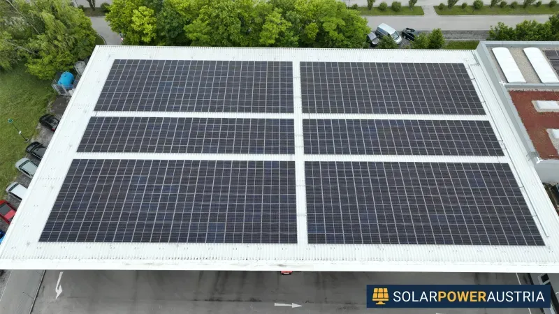 Luftaufnahme von sechs Photovoltaik-Feldern auf einem großen Flachdach