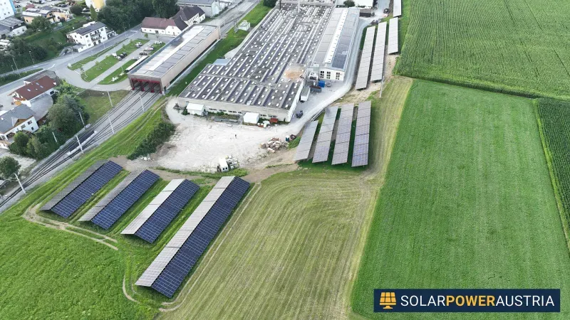 Luftaufnahme eines Betriebsareals mit Photovoltaik auf Dach- und Freifläche