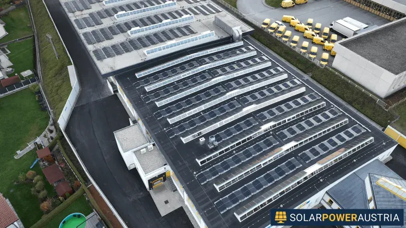 Luftaufnahme eines Hallendachs mit reihenweise montierten Photovoltaik-Modulen