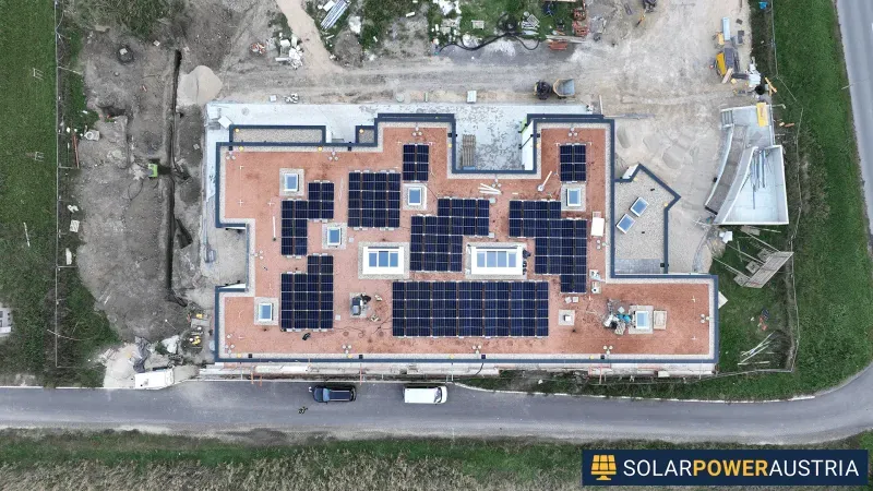Luftaufnahme einer Photovoltaik-Anlage auf dem Dach eines mehrgeschossigen Gebäudes