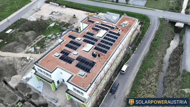Luftaufnahme einer Photovoltaik-Anlage auf dem Flachdach eines Neubaus