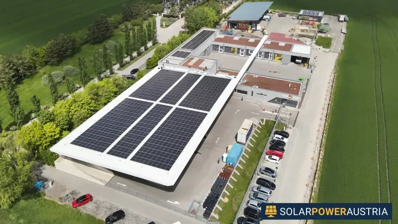 Luftaufnahme einer Photovoltaik-Anlage auf einem langgestreckten Betriebsgebäude