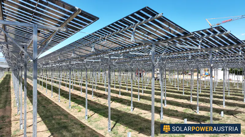 Photovoltaik-Unterkonstruktion im Bau: Stahlständer mit ersten Modulreihen und Baukran